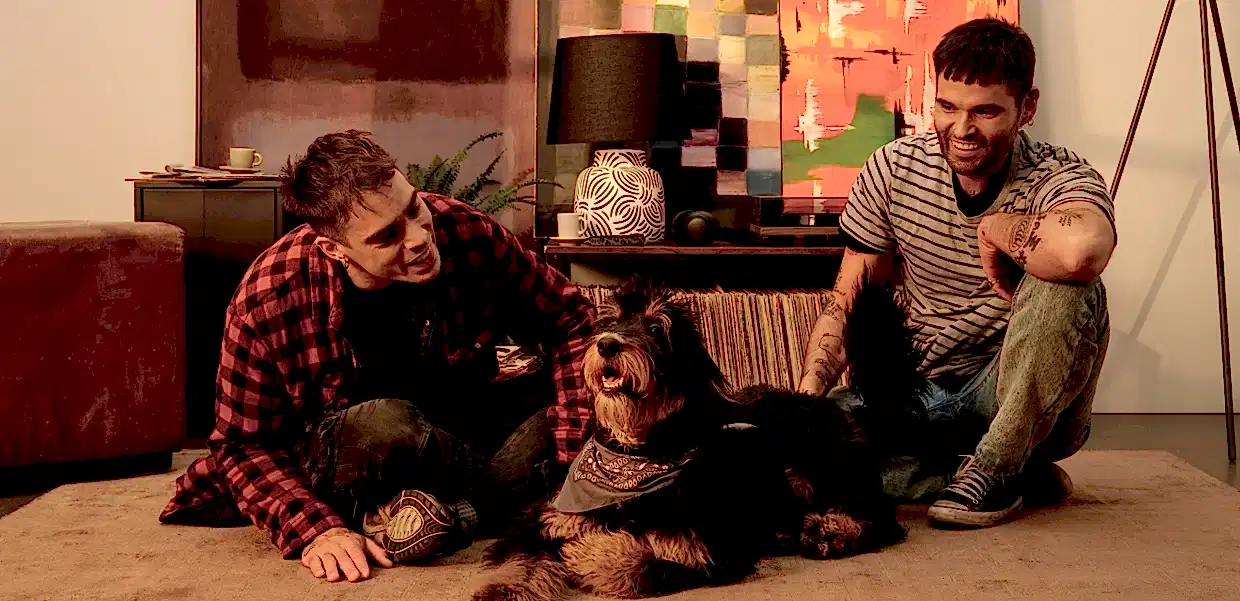 Two men sat on the floor in their home looking at their dog